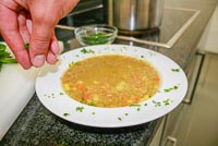 Anrichten und Dekorieren des Suppentellers